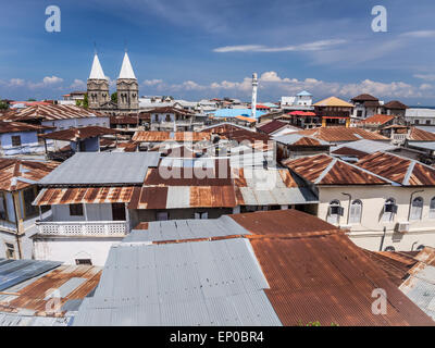 Architecture in Stone Town, Zanzibar in Tanzania with towers of the St. Joseph's Cathedral, mosque's minaret and typical roofs. Stock Photo