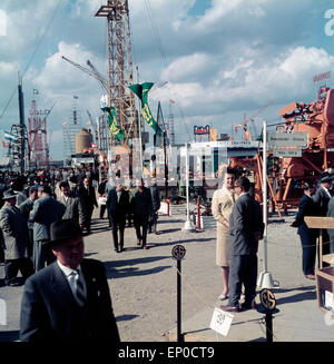 Besucher sehen sich die einzelnen Stände und Pavillons auf der Hannover Messe 1964 an. Visitors and customers walking over the H Stock Photo