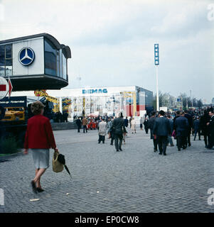 Besucher sehen sich die einzelnen Stände und Pavillons auf der Hannover Messe 1964 an. Visitors and customers walking over the H Stock Photo