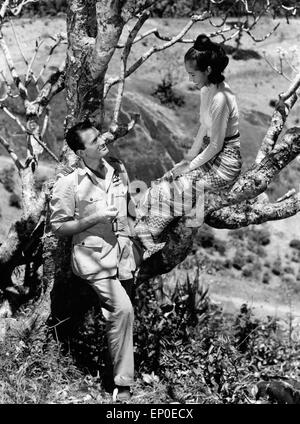 Gregory Peck und Win Min Than während einer Drehpause am Filmset von 'Flammen über Fernost', 1954. Having a break at the film se Stock Photo