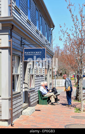 Nantucket Massachusetts on Nantucket Island. Gift shop on downtown street with men talking and sitting on bench outside Stock Photo
