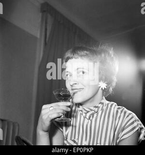 Porträt einer jungen Frau mit einem Likörglas im Deutschland der 1950er Jahre. Portrait of a young woman with a galss of liquor, Stock Photo