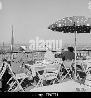 Menschen sitzen 1956 in einem Dachgarten Restaurant und genießen bei Kaffee den Ausblick auf die Stadt Hamburg. People sitting i Stock Photo