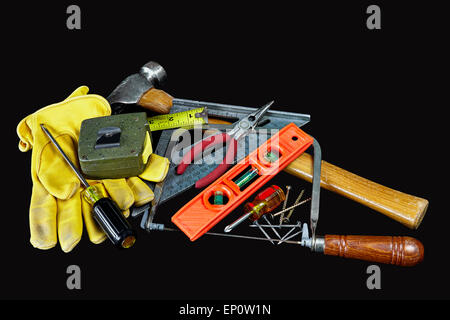 Carpenter tools, hammer, nails, screws, level, tape measure, screwdrivers, pliers and hacksaw isolated on black background Stock Photo