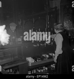 Wirtin in einem Pub in London, an dem Abend, als Bill Haley sein Konzert gibt, Großbritannien 1950er Jahre. Innkeeper at a pub i Stock Photo