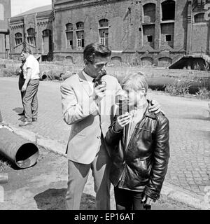 Der amerikanische Schauspieler George Nader simjuliert die Festnahme eines Jugendlichen auf einem alten Fabrikgelände, Deutschla Stock Photo