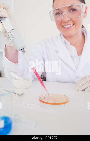Attractive red-haired scientist using a pipette Stock Photo