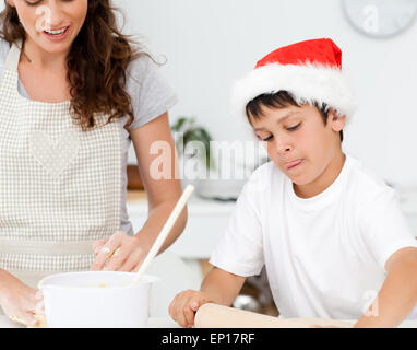 Cute boy preparing christmas biscuits with his mother Stock Photo