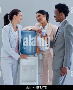 Business people speaking next to a water cooler Stock Photo
