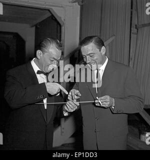 Zwei Männer spielen mit einem Dirigentenstab in Hamburg, Deutschland 1950er Jahre. Two man playing with a conductor's baton at H Stock Photo