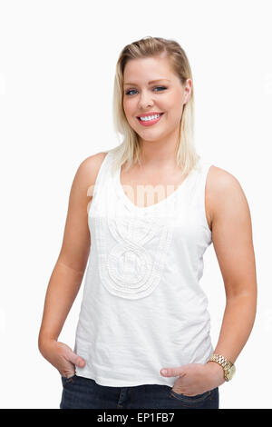 Happy blonde woman placing her hands in her pockets Stock Photo