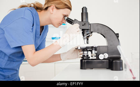 Female scientist looking through a microscope Stock Photo