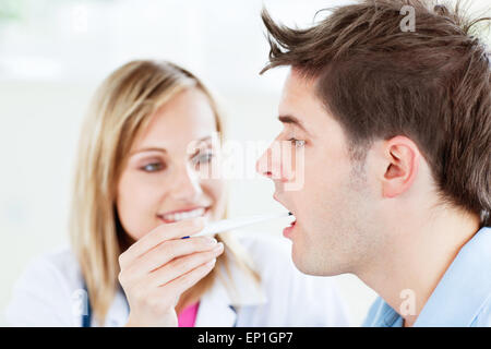 Woman doctor taking the temperature of her patient Stock Photo