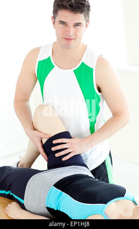 Attractive male physical therapist checking a woman's leg Stock Photo
