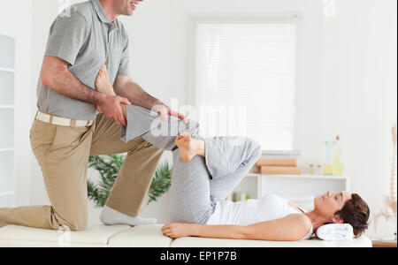Chiropractor stretching woman's leg Stock Photo