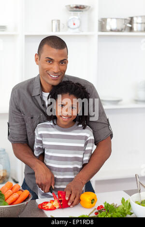 Smiling father helping his son cut vegetables Stock Photo - Alamy