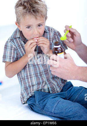 Cold child taking syrup Stock Photo