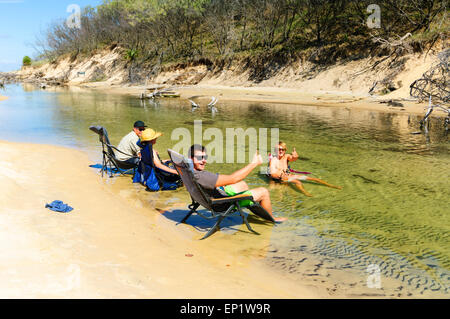 Young Persons sitting on Chairs in the River and Drinking, Eli Creek, Fraser Island, Queensland, QLD, Australia Stock Photo