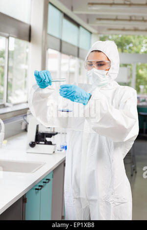 Portrait of a protected scientist pouring liquid in a Erlenmeyer Stock Photo