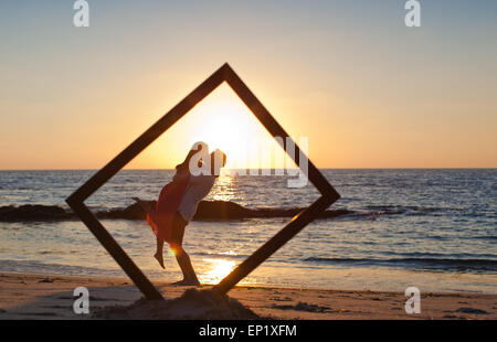 Silhouette of a couple at the beach in a frame Stock Photo