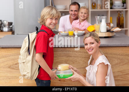 Attentive mother packing the school lunch to his son Stock Photo
