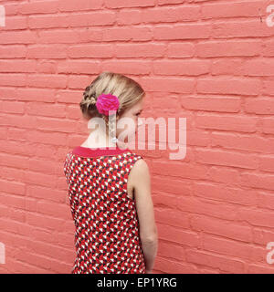 Side view of a girl with a plait and a flower in her hair Stock Photo