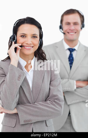 Smiling call center agents with headsets on and arms folded Stock Photo
