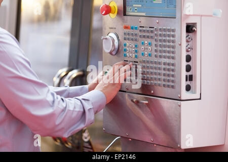 hand on the control panel of a programmable machine Stock Photo