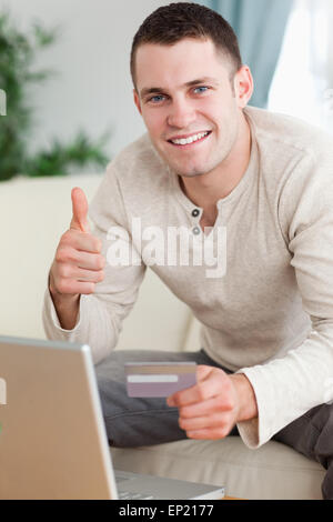 Portrait of a man purchasing online with the thumb up Stock Photo
