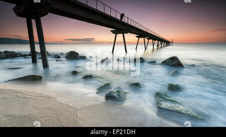 Person standing on a pier at sunrise, Barcelona, Spain Stock Photo