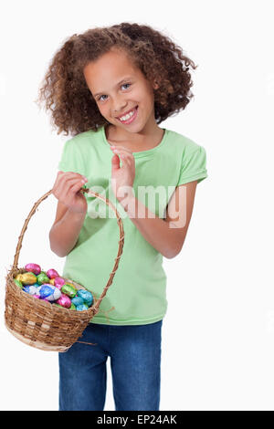 Portrait of a cute girl holding a basket full of Easter eggs Stock Photo