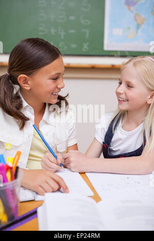 Happy schoolgirls working together in class Stock Photo - Alamy