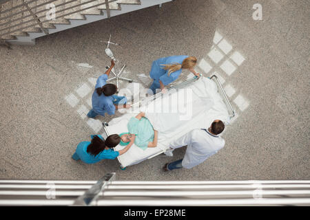 Three nurses and one doctor pushing one patient in a bed Stock Photo