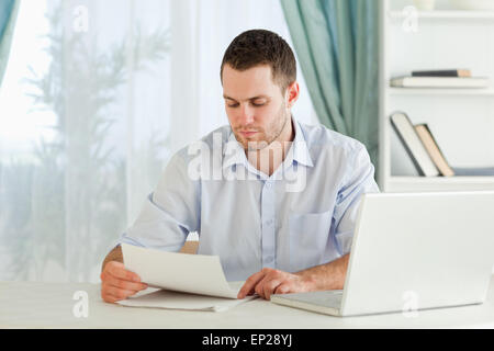 Businessman reading a letter in his homeoffice Stock Photo