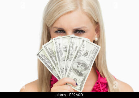 Blonde hiding her face with 100 dollars banknotes Stock Photo