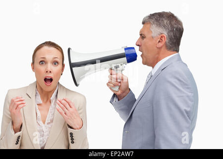 Businessman using a megaphone after his colleague Stock Photo