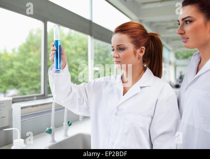 Science students looking at a graduated cylinder Stock Photo