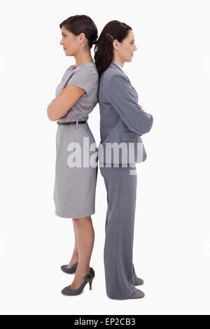 Two businesswomen standing back to back with folded arms Stock Photo ...