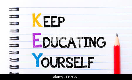 KEY as Keep Educating Yourself Text written on notebook page, red pencil on the right. Motivational Concept image Stock Photo