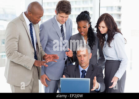 Business team seriously talking in front of a laptop Stock Photo