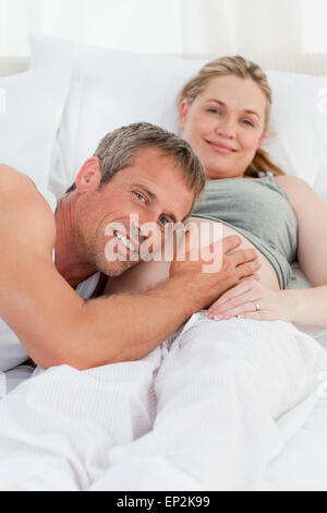 Husband listening to his wife's belly Stock Photo