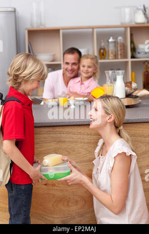 Caring mother packing the school lunch to his son Stock Photo
