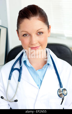 Self-assured female doctor smiling at the camera sitting Stock Photo