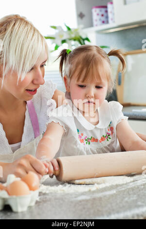 Attentive young mother baking with her daughter Stock Photo