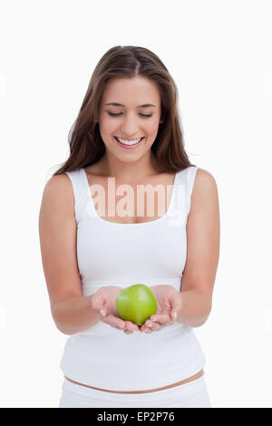 Smiling brunette woman holding a beautiful green apple Stock Photo