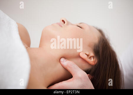 Close-up of physiotherapist pressing his thumb on the neck of a woman Stock Photo