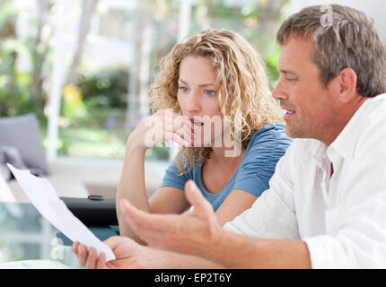 Desperate couple calculating their domestic bills Stock Photo