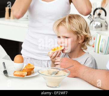 Serious boy eating a toast with marmalade during breakfast Stock Photo
