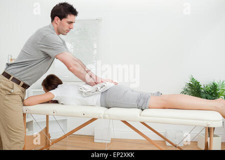 Woman lying while being massaged with a towel Stock Photo