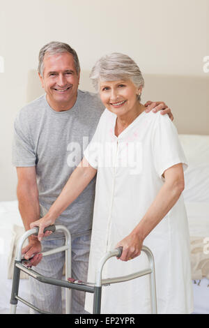 Man helping his wife to walk Stock Photo